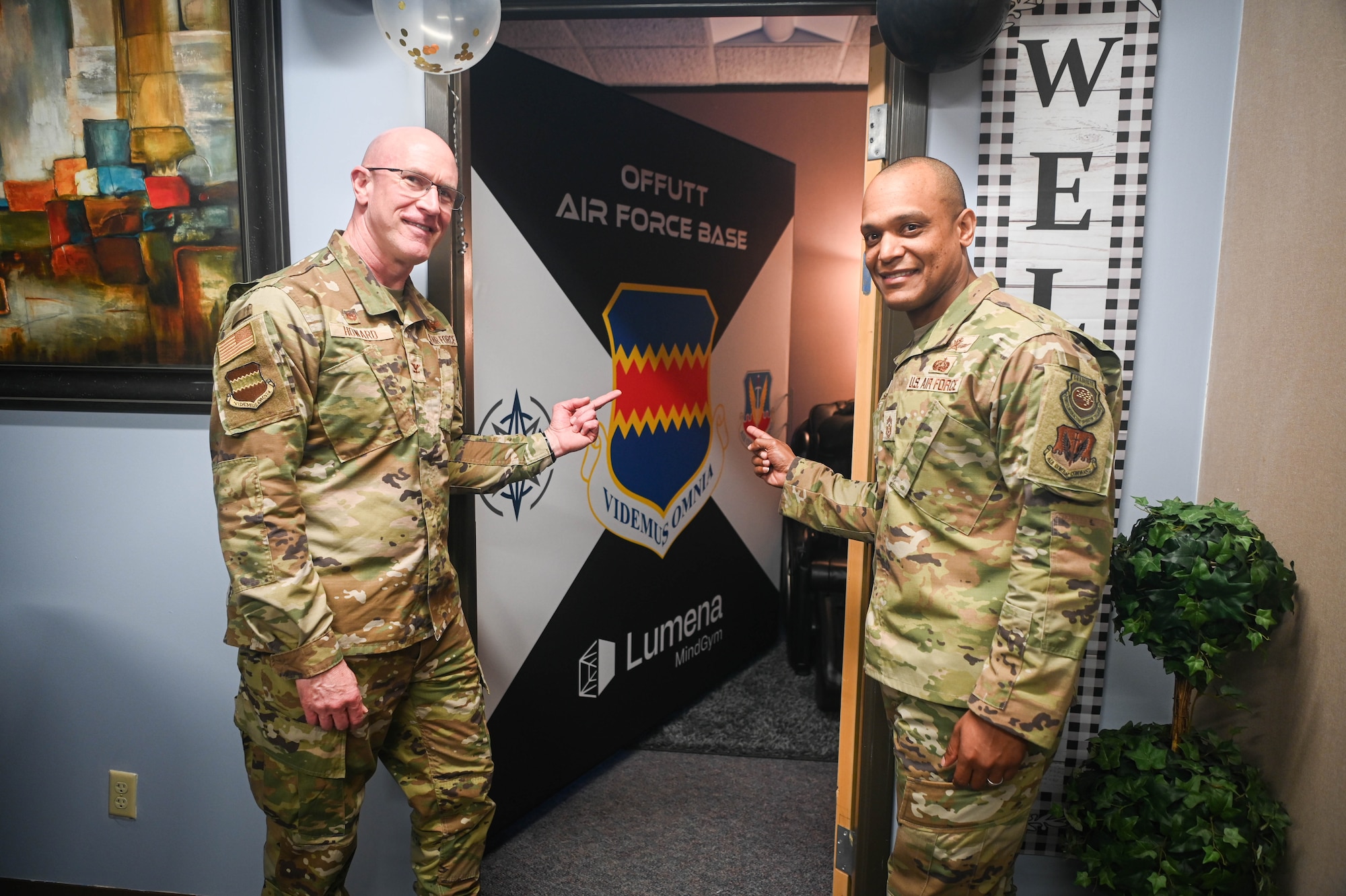 Col. Mark Howard, 55th Wing commander, and Chief Master Sgt. Andrew Small, 55th Wing command chief, point to the new MindGym located in building 323, May 15, 2025. MindGym is a seven-foot tall cube which uses light, reflection, calming sounds, and guided instruction as part of the immersive experience. (U.S. Air Force photo by Daniel Martinez)