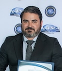 Evan Sarantos, Naval Surface Warfare Center Panama City Division’s Expeditionary Sea Base Command, Control, Communications, Computers, and Intelligence Project lead systems engineer, receives the NSWC PCD FY24 Annual Award for Technical Excellence, March 27. This mission is essential to supporting the Force Behind the Fleet as a crucial element for effective modern warfare in complex and dynamic environments. (U.S. Navy photo by Eddie Green)