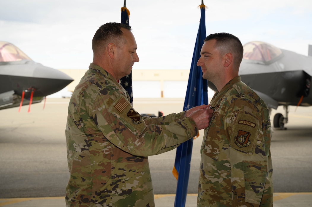 U.S. Air Force Col. Jerry Copeland, 354th Maintenance Group commander, awards Maj. John Ritschard, 356th Fighter Generation Squadron outgoing commander, with the Meritorious Service Medal during a change of command ceremony