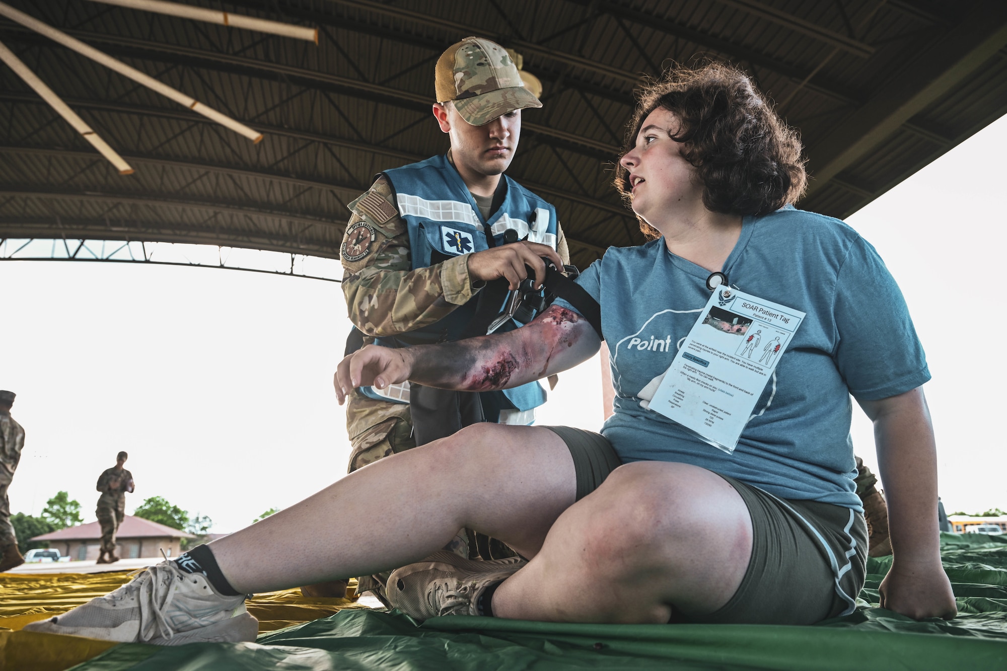 A man in uniform tends to a simulated patient.