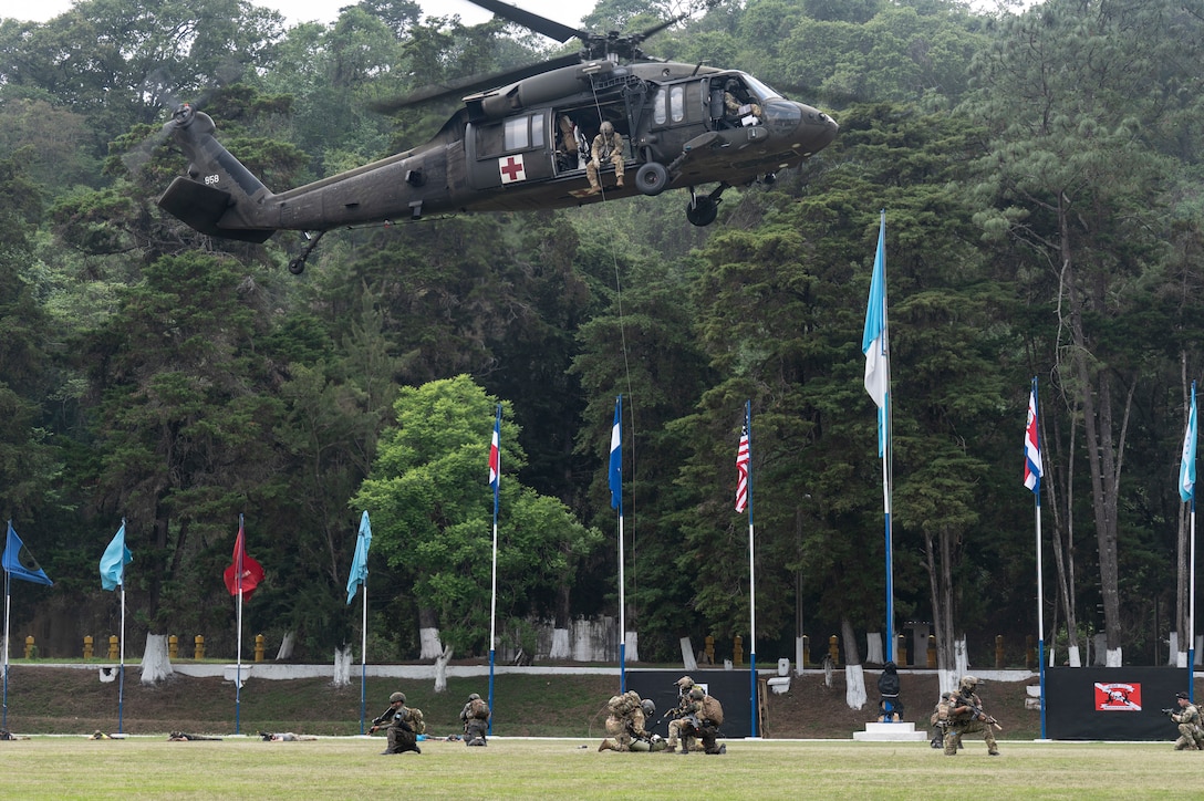 A U.S. Army helicopter hovers above U.S. and Guatemalan service members