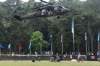 A U.S. Army helicopter hovers above U.S. and Guatemalan service members