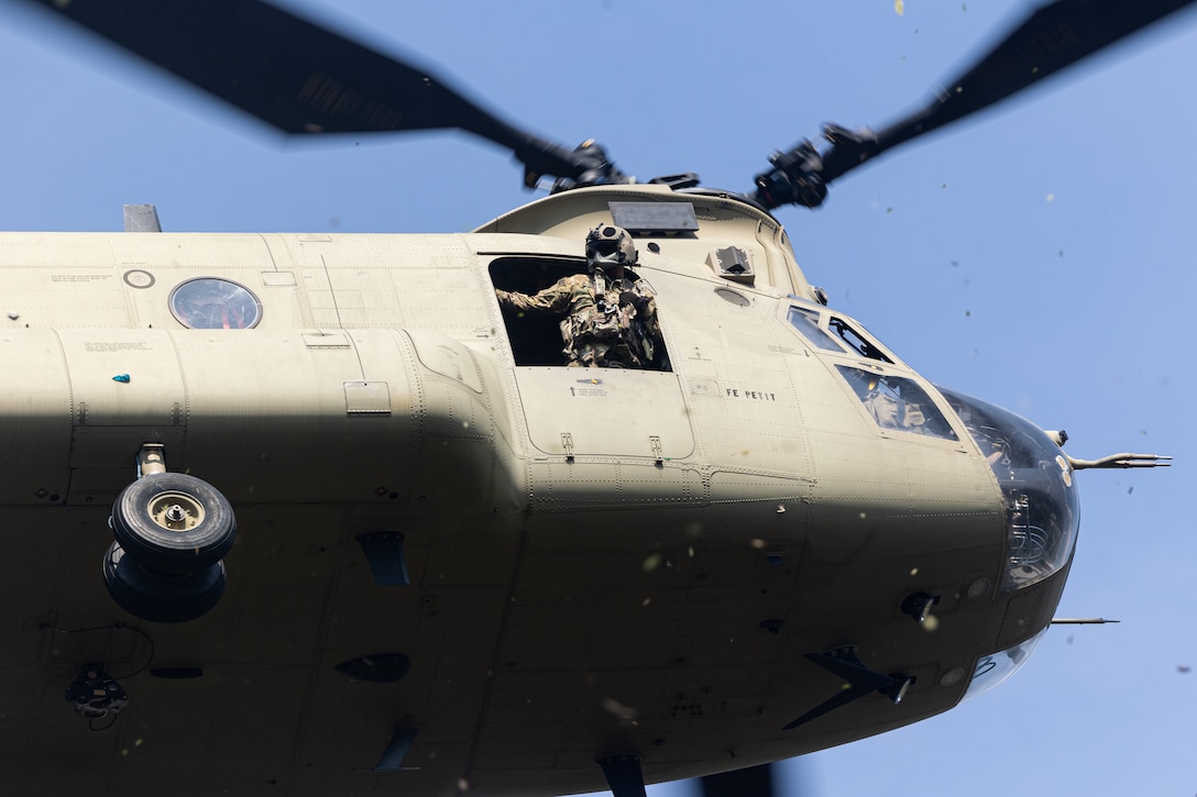 U.S. service member looks out of an army helicopter mid flight