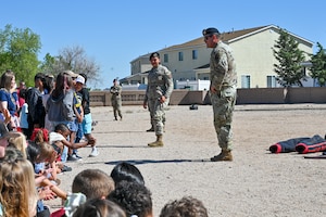 U.S. Air Force Defenders engage with students during a Police Week outreach event at Kirtland Air Force Base, N.M., May 9, 2025. The event gave children a hands-on opportunity to learn about law enforcement roles and responsibilities while building positive relationships with Security Forces members. (U.S. Air Force photo by Airman 1st Class Donnell Schroeter)