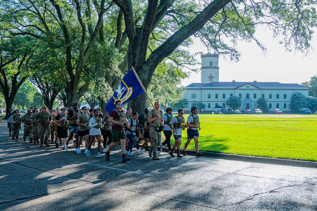 A group of Airmen at Barksdale Air Force Base, Louisiana, jog with the security forces flag during a 24-hour Police Week ruck, May 22, 2025. The 24-hour ruck was one of the many events held to commemorate Police Week. (U.S. Air Force photo by Airman 1st Class Aaron Hill)