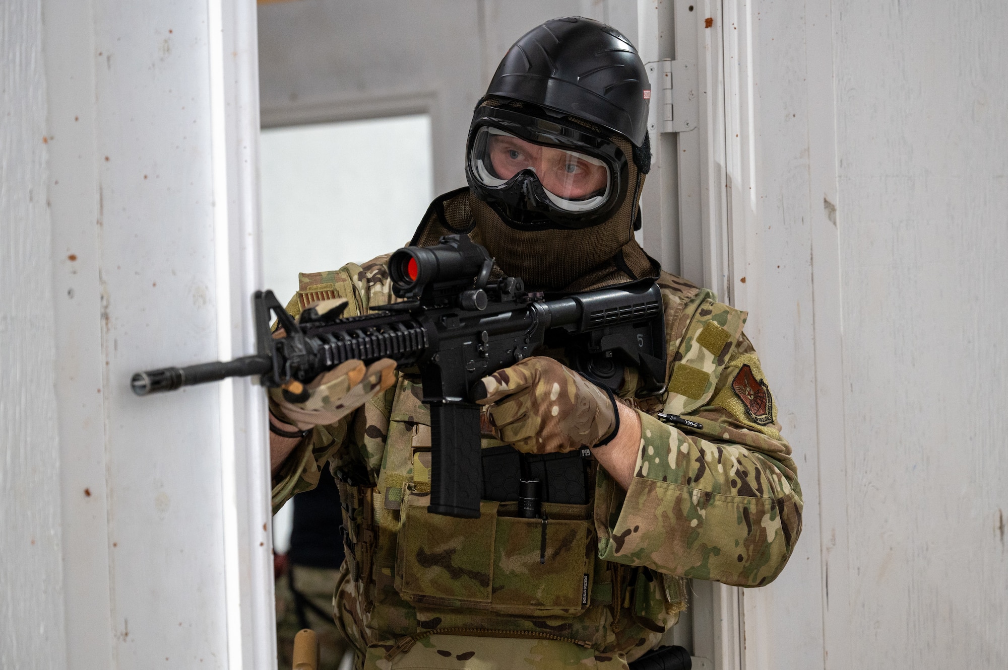 U.S. Air Force Tech. Sgt. Dustin Worell, 2nd Security Forces Squadron flight sergeant, aims an M4 carbine rifle during a close quarters battle hostage scenario at Barksdale Air Force Base, Louisiana, May 21, 2025. 2nd Bomb Wing Airmen from different career fields participated in various exercises and competitions to strengthen their skills during the observance of Police Week. (U.S. Air Force photo by Airman 1st Class Preston Crawford)