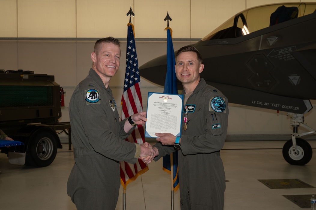 U.S. Air Force Lt. Col. Jay Doerfler, right, 354th Range Squadron outgoing commander, receives the Meritorious Service Medal from Col. Curtis Dougherty, 354th Operations Group commander, during a change of command ceremony