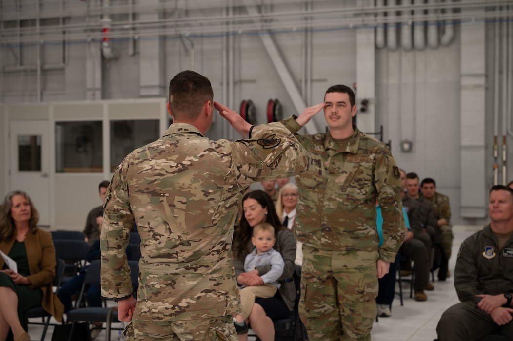 U.S. Air Force Maj. Joseph Hamilton, 354th Range Squadron incoming commander, renders an initial salute to Staff Sgt. Niles Klawitter, 354th Range Squadron range scheduler, during a change of command ceremony