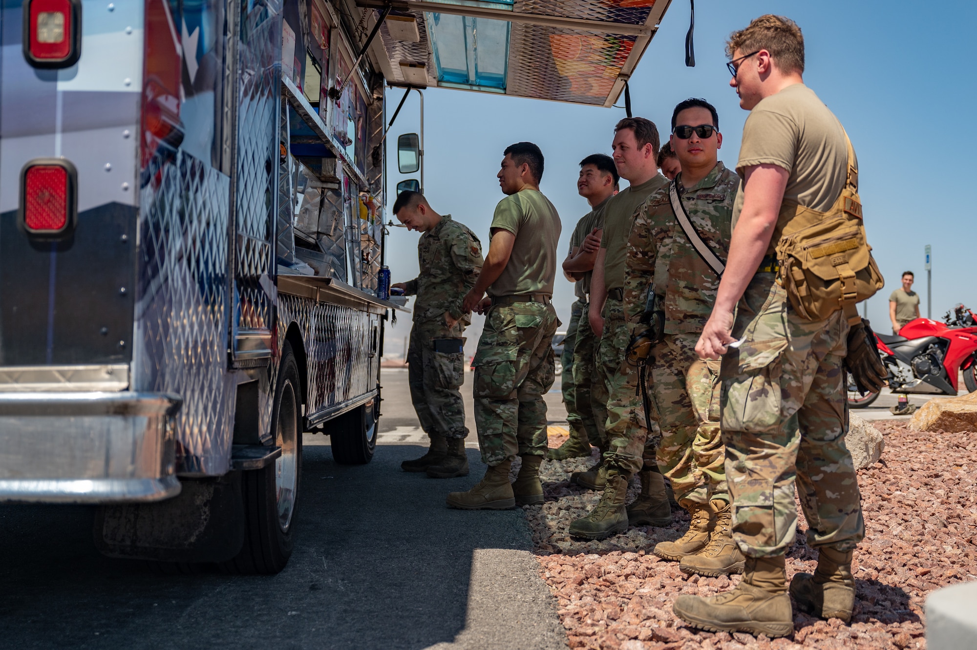 Airmen stand in line at food truck.