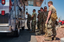 Airmen stand in line at food truck.