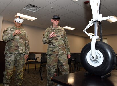Sgt. 1st Class Yun Sung, left, and Master Sgt. William Harbeson try out augmented reality technology that could be an option for use in the military sustainment community during a Healthcare Technology Management Week summit, hosted by U.S. Army Medical Logistics Command May 21-22 at Fort Detrick, Maryland.
