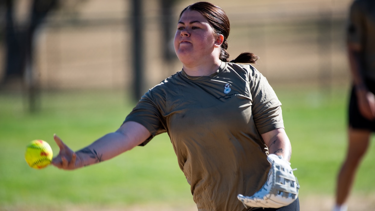 Airman throws a softball pitch