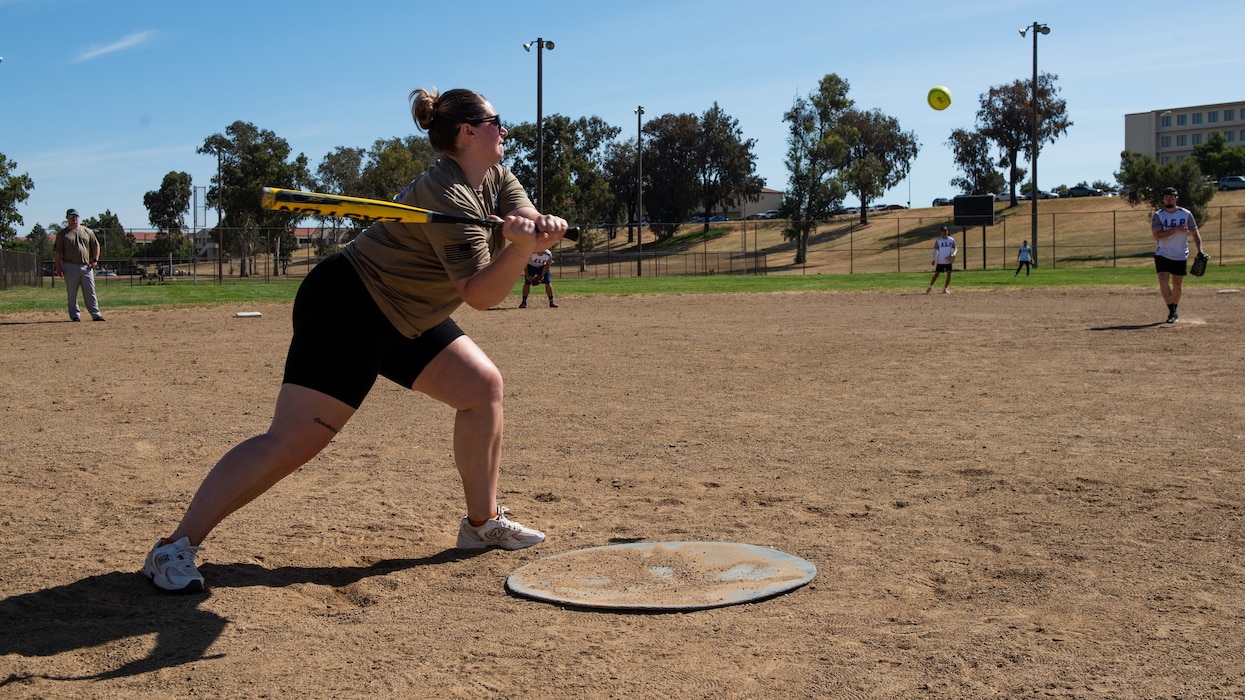 Airman swings at a softball pitch