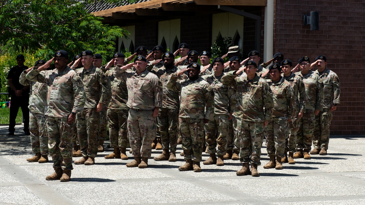 Airmen salute during a ceremony