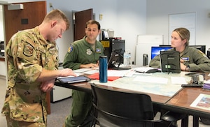 From left, U.S. Air Force Capt. Thomas Michinock, Maj. Andrew Lucchesi and 1st Lt. Annmarie Boswell, 3rd Airlift Squadron C-17 Globemaster III pilots, discuss mission planning details during an aircrew briefing at Dover Air Force Base, Delaware, May 27, 2025. The 3rd AS provides global reach with unique, outsized and oversized airlift capability. The unit supports global engagement through direct delivery of time-critical theater deployment assets and ensures combat readiness of Air Mobility Command active-duty C-17 airlift crews. (U.S. Air Force photo by Roland Balik)