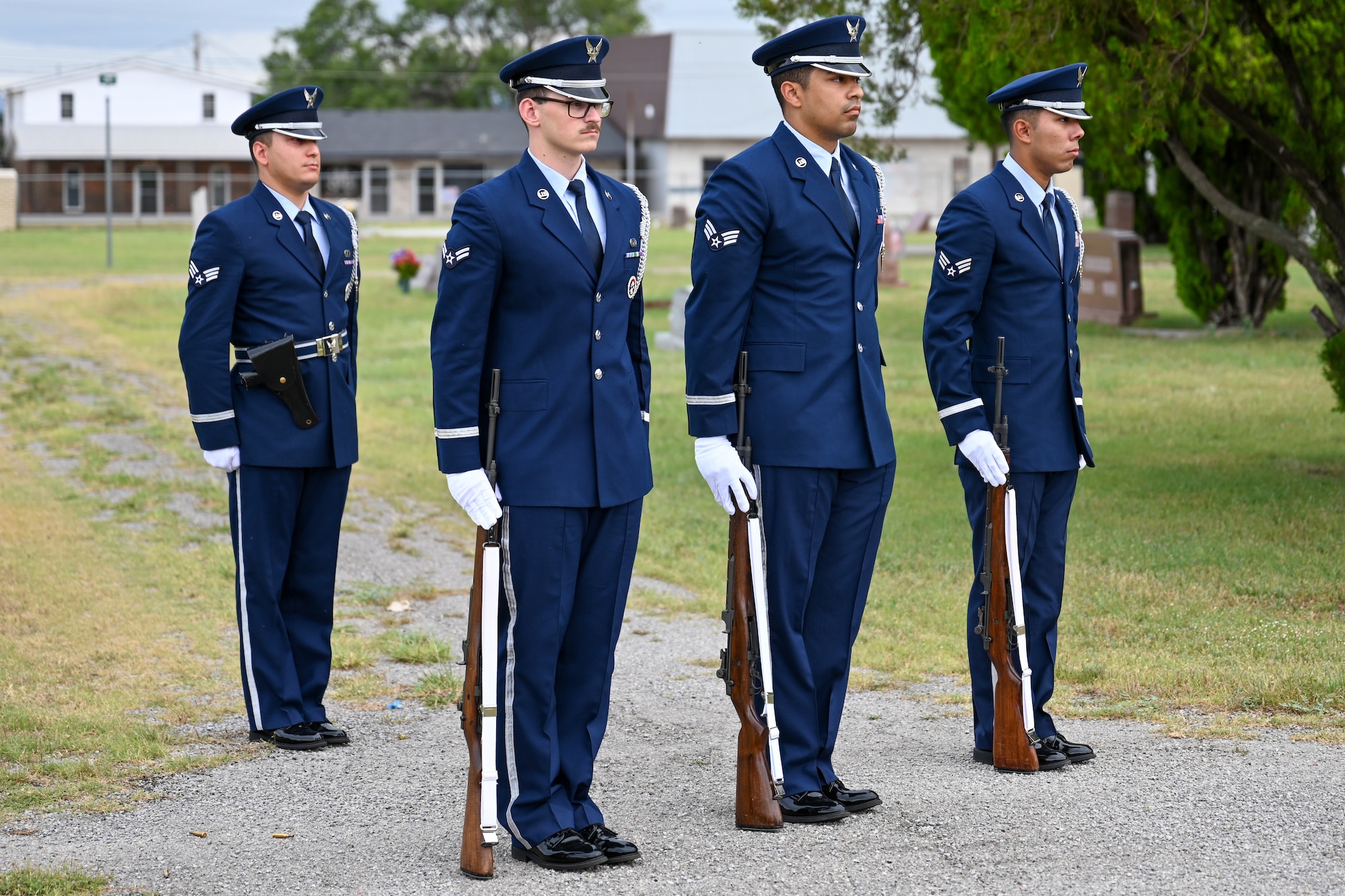 Airmen from the Blue Knights honor guard at Altus Air Force Base stand at attention during taps at the Altus City Cemetery in Altus, Oklahoma, May 26, 2025. The Blue Knights also performed a three-volley salute for Memorial Day to honor fallen veterans. (U.S. Air Force photo by Airman1st Class Nathan Langston)
