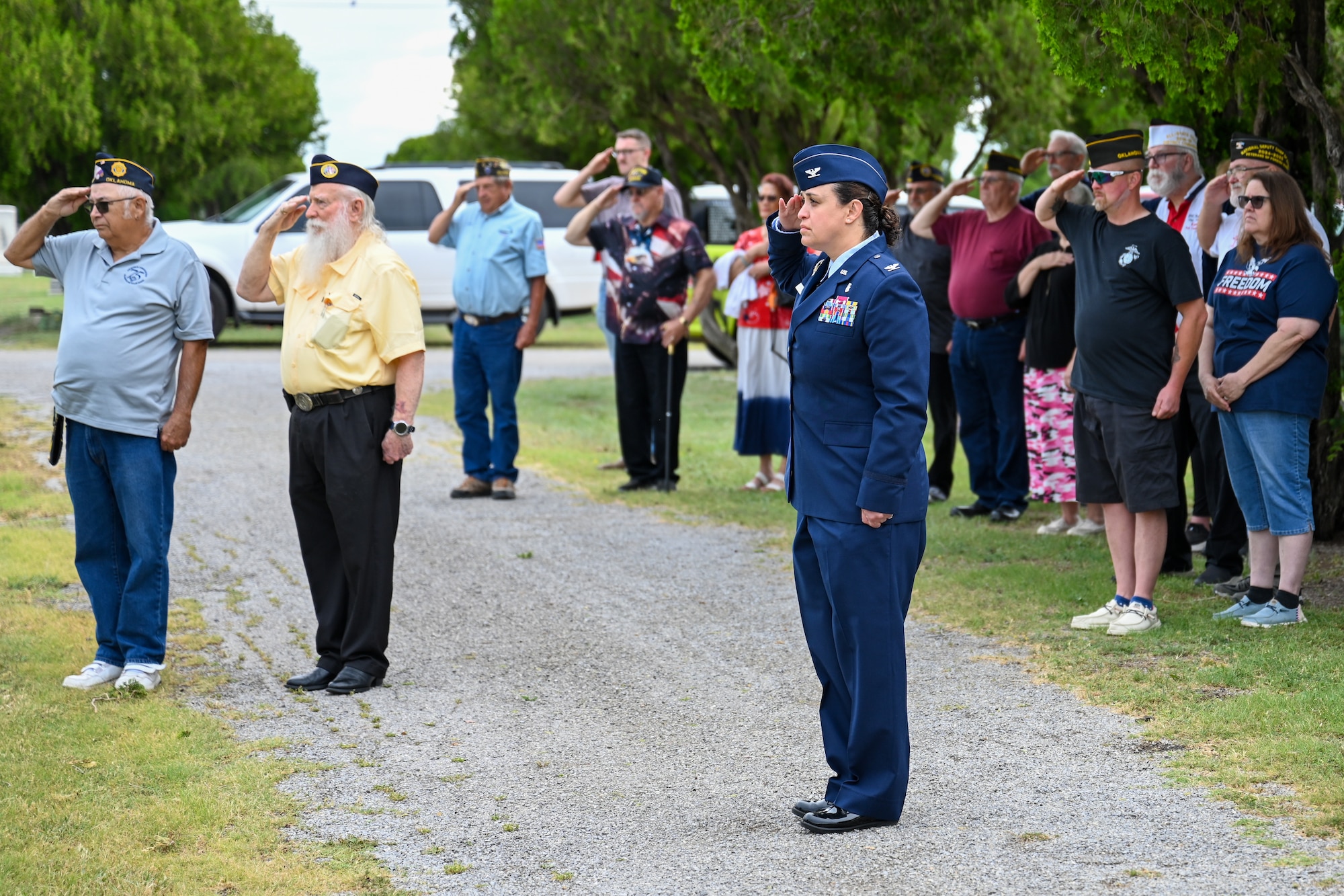 U.S. Air Force Col. Claudia Eid, 97th Medical Group commander, salutes during taps at the Altus City Cemetery in Altus, Oklahoma, May 26, 2025. Taps is played as a tribute to fallen service members. (U.S. Air Force photo by Airman 1st Class Nathan Langston)