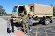 Local students meet Spc. Kevin Silva, G3, 85th U.S. Army Reserve Support Command, during a Touch a Truck community event, May 23, 2025.