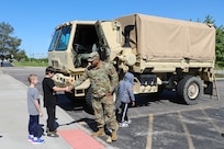 Local students meet Spc. Kevin Silva, G3, 85th U.S. Army Reserve Support Command, during a Touch a Truck community event, May 23, 2025.