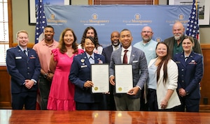 City of Montgomery Mayor Steven L. Reed and U.S. Air Force Col. Shamekia Toliver pose with several members of Maxwell Air Force Base on May 28, 2025, at City Hall, who implemented and executed the intergovernmental support agreement to open the pool and directly support the service members and families on Maxwell. The IGSA provides seasonal lifeguard services to the base pool and allows for efficient resource sharing between the city and Maxwell benefiting both parties and strengthening partnerships in the community.