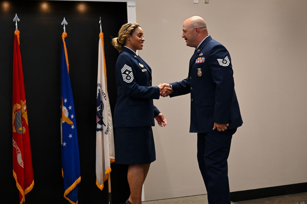 U.S. Air Force Tech. Andrew Fruehuan, 312th Training Squadron instructor, shakes hands with Chief Master Sgt. Khamillia Washington, 17th Training Wing command chief, as he walks across the stage during Goodfellow’s Community College of the Air Force Fall ‘24 and Spring ‘25 Graduation Ceremony at the Powell Event Center, Goodfellow Air Force Base, Texas, May 21, 2025. Graduates received degrees in criminal justice, intelligence studies and technology, fire science and instructor of technology and military science. (U.S. Air Force photo by Senior Airman Evelyn J. D’Errico)