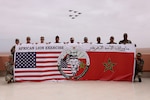 U.S. Marines and Soldiers from the Royal Moroccan Armed Forces pose for a group photo while F16 fighter jets pass overhead at Cap Draa during African Lion 25 (AL25) in Tan-Tan, Morocco, May 23, 2025. AL25, the largest annual military exercise in Africa, brings together over 50 nations, including seven NATO allies and 10,000 troops to conduct realistic, dynamic and collaborative training in an austere environment that intersects multiple geographic and functional combatant commands. Led by U.S. Army Southern European Task Force, Africa (SETAF-AF) on behalf of the U.S. Africa Command, AL25 takes place from April 14 to May 23, 2025, across Ghana, Morocco, Senegal, and Tunisia. This large-scale exercise will enhance our ability to work together in complex, multi-domain operations—preparing forces to deploy, fight and win.