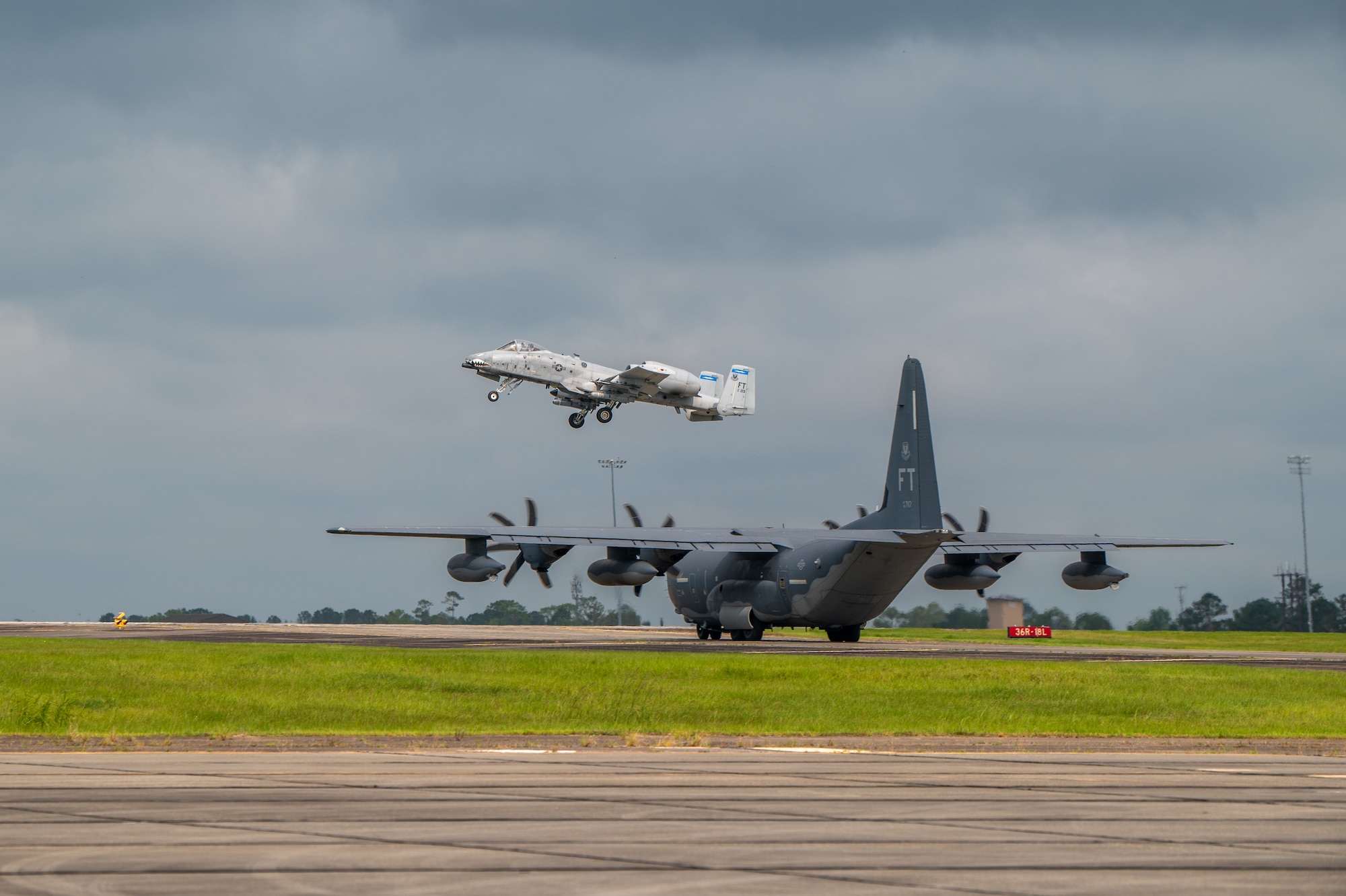 Plane in the foreground stands still, as another plane flies through the air.