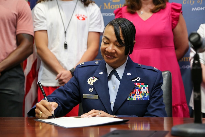 U.S. Air Force Col. Shamekia Toliver, 42d Air Base Wing commander, signs the Decree of Mutual Support Quality-of-Life Initiative between the City of Montgomery and Maxwell Air Force Base on May 28, 2025, in City Hall, celebrating the recent intergovernmental support agreement that provides seasonal lifeguard services to the base pool. The IGSA allows for efficient resource sharing and collaboration between the city and Maxwell benefiting both parties and strengthening partnerships in the community.