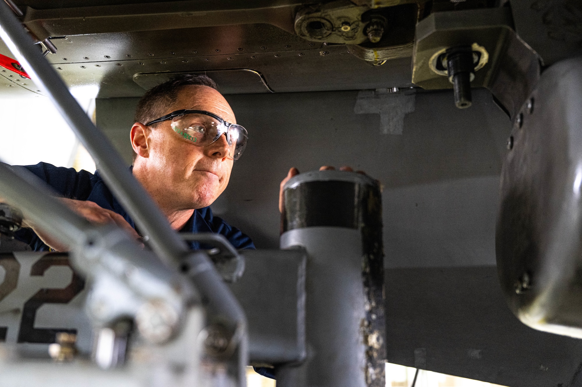An Airman performs maintenance on a jet.
