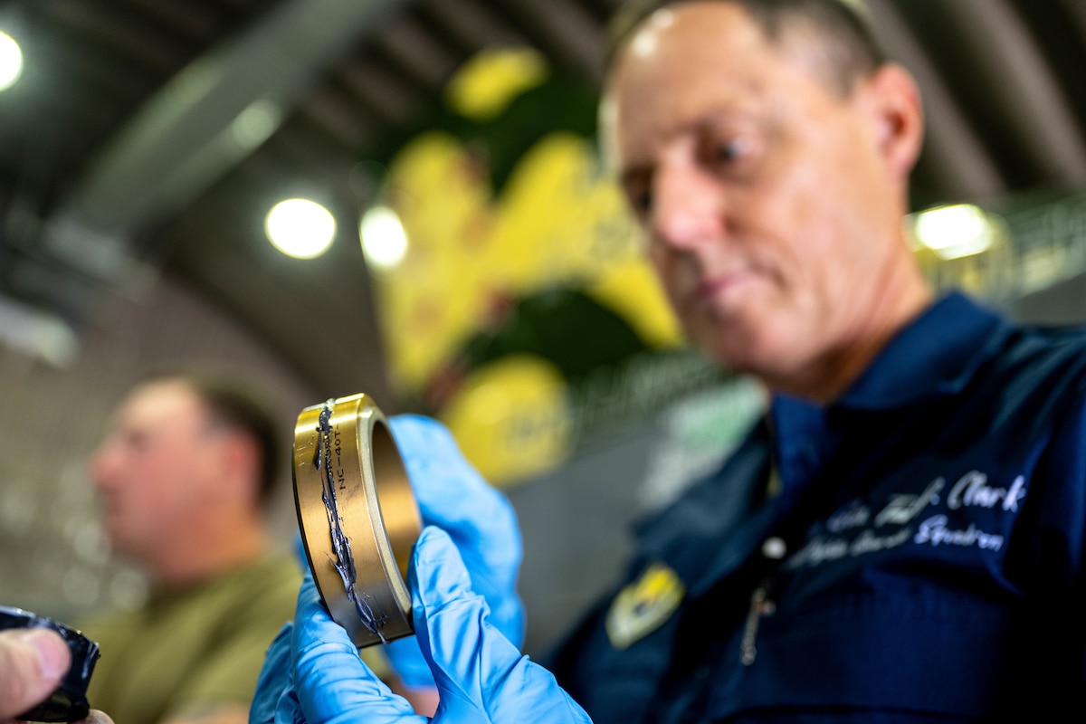 An Airman performs maintenance on a jet.