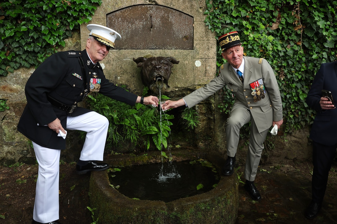 U.S. Marine Corps Gen. Christopher Mahoney, the Assistant Commandant of the Marine Corps, left, and a French key leader, right, drink from Devil Dog Fountain in Belleau Wood, France, May 25, 2025. The memorial ceremony was held in commemoration of the 107th anniversary of the battle of Belleau Wood, conducted to honor the legacy of service members who gave their lives in defense of the United States and European allies.