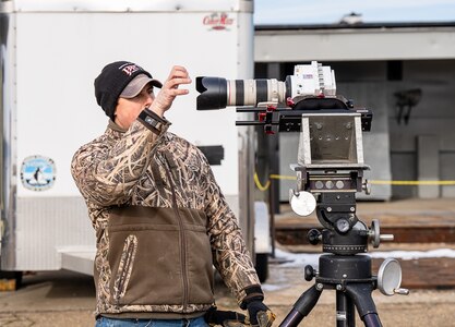DAHLGREN, Va. — Engineer technician Philip Sisson adjusts a high-speed camera in preparation for an upcoming range test at the Potomac River Test Range. Engineers at Naval Surface Warfare Center Dahlgren Division deploy a range of high-speed cameras capable of capturing up to 75,000 frames per second to better understand and refine the lethality and effectiveness of the Navy’s munitions. (Dave Ellis/NSWCDD Photo)