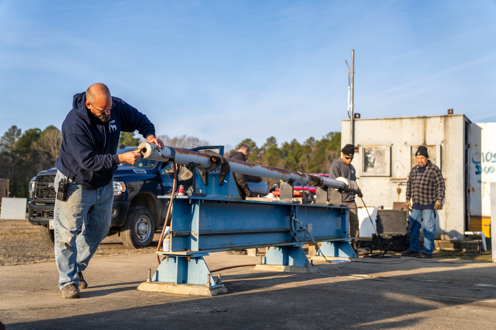 PUMPKIN NECK, Va. — Naval Surface Warfare Center Dahlgren Division’s firing director Mark Kristofik, and engineering technicians Troy Deshazo, Daquan Carter and Bob Wilson work together to clean and prepare a fragment impact gun before it is used for testing. (Dorina Watermolen/NSWCDD Photo)