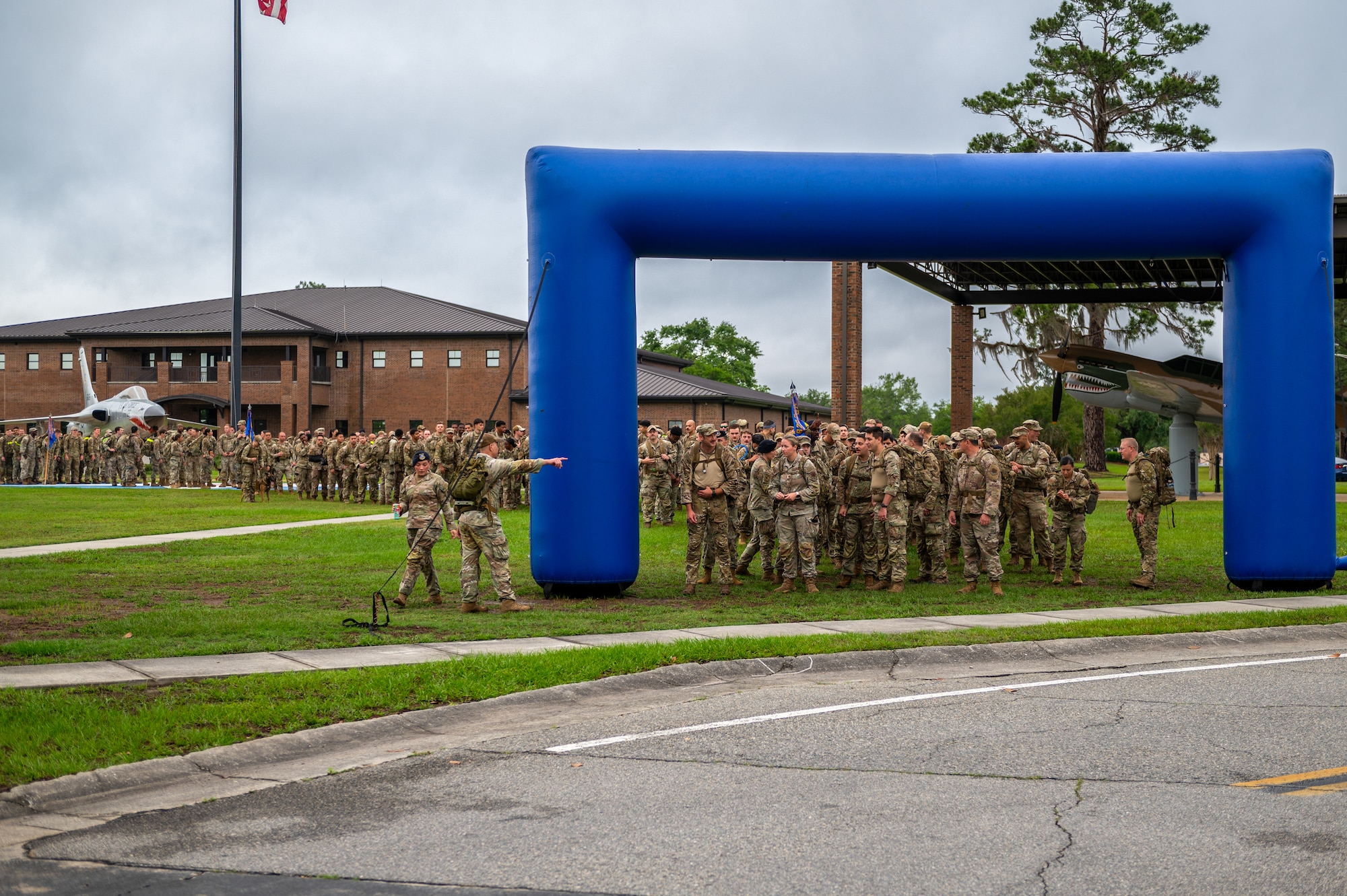 Group of individuals stand under a blown up arch.