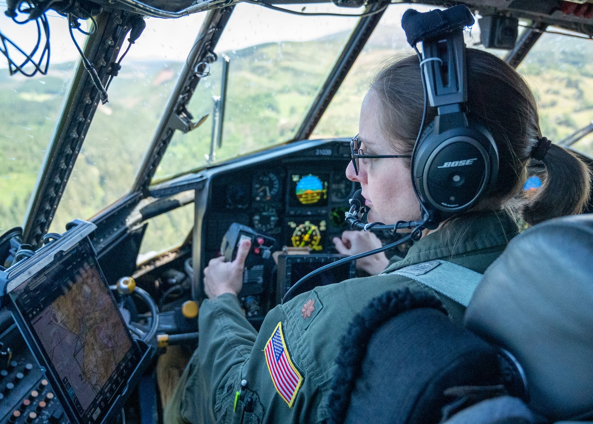A female pilot is at the controls of a C-130H Hercules