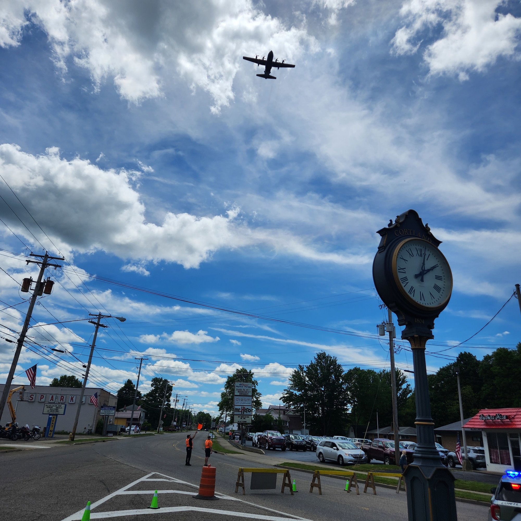 A C-130H Hercules aircraft, assigned to the 910th Airlift Wing at nearby Youngstown Air Reserve Station, Ohio, approaches the Cortland Triangle in Cortland, Ohio, for a flyover of the city’s Memorial Day ceremony on May 26, 2025.