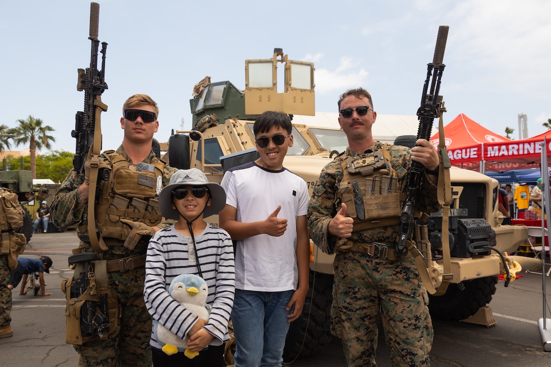 U.S. Marine Corps Lance Cpl. Justin James, left, and Lance Cpl. Drew Cloutier, both riflemen with 3rd Light Armored Reconnaissance Battalion, pose for a photograph with expo attendees at the Fleet Week Expo in San Pedro, California, during Los Angeles Fleet Week, May 25, 2025. Los Angeles Fleet Week, now in its eighth iteration, is a sea service celebration that allows citizens of Greater Los Angeles to witness today’s maritime capabilities firsthand. Nearly 1,000 Sailors, Marines, and Coast Guardsmen will showcase their capabilities and equipment, participate in various community service events, and enjoy the hospitality of Los Angeles during the event. (U.S. Marine Corps photo by Cpl. Bruin Largent)