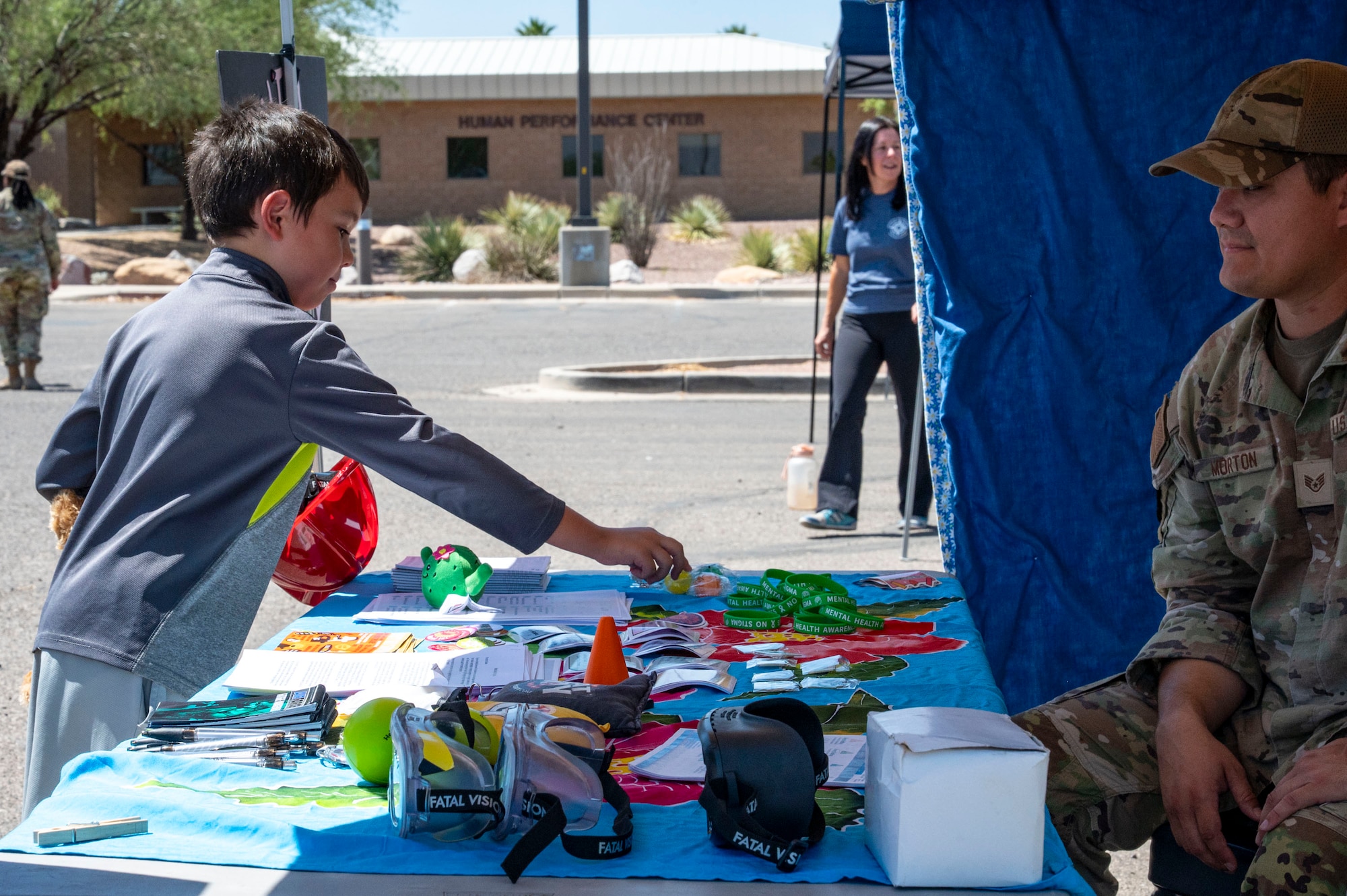 A child grabs a free item from the Mental Health booth during the Health Fair at Davis-Monthan Air Force Base, Arizona, May 28, 2025. The 355th Medical Group’s Health Fair brought together awareness outreach, interactive wellness stations and educational resources to strengthen the health, preparedness and resilience of the community. (U.S. Air Force photo by Airman Samantha Melecio)