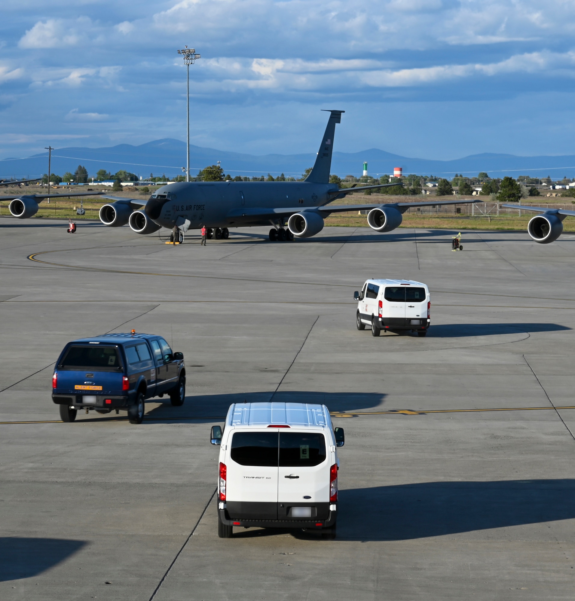 Cars drive out to airplanes on a flightline