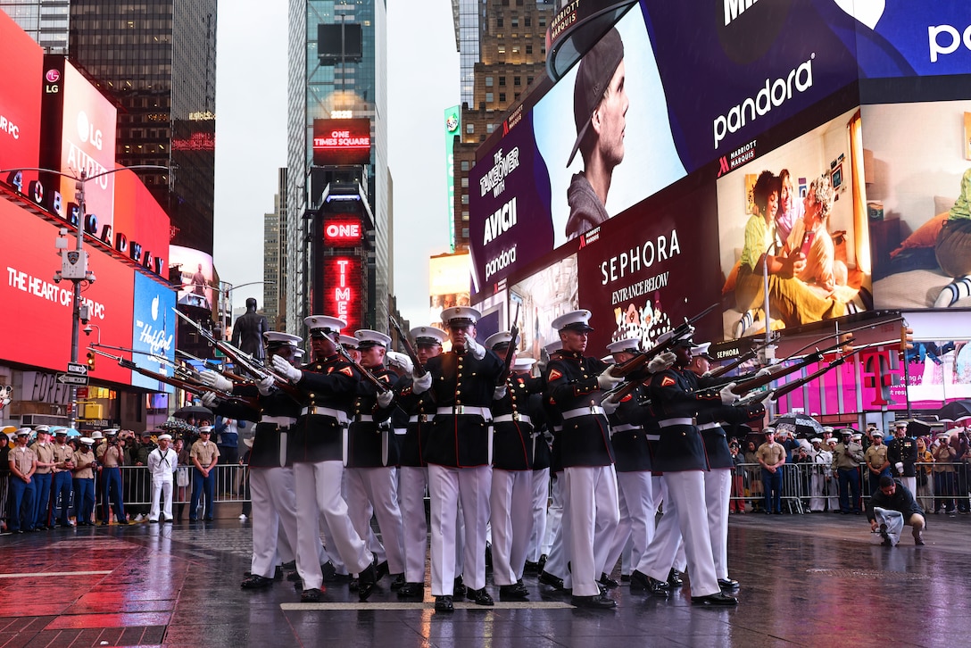 U.S. Marines with the United States Marine Corps Silent Drill Platoon execute their "bursting bomb" sequence during Fleet Week New York in Times Square, New York City, N.Y., May 21, 2025. FWNY is an annual celebration where U.S. Navy, Marine Corps, and Coast Guard ships dock in New York City, allowing the public to tour vessels and meet service members. (U.S. Marine Corps photo by Lance Cpl. Christopher Prelle)