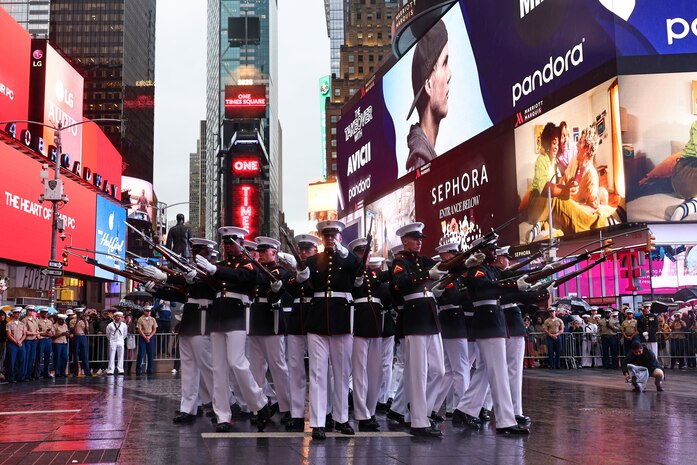 U.S. Marines with the United States Marine Corps Silent Drill Platoon execute their "bursting bomb" sequence during Fleet Week New York in Times Square, New York City, N.Y., May 21, 2025. FWNY is an annual celebration where U.S. Navy, Marine Corps, and Coast Guard ships dock in New York City, allowing the public to tour vessels and meet service members. (U.S. Marine Corps photo by Lance Cpl. Christopher Prelle)