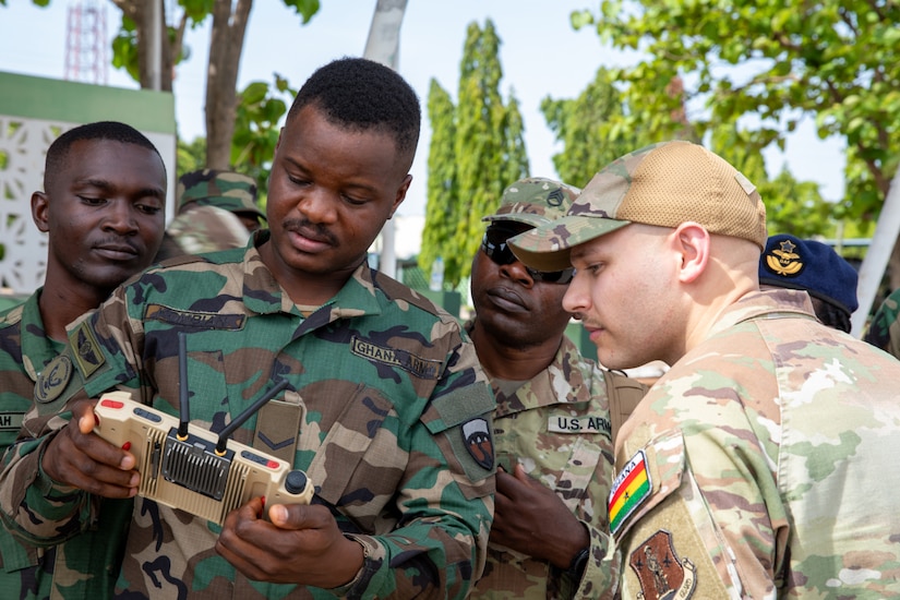 Troops gather around a drone controller.