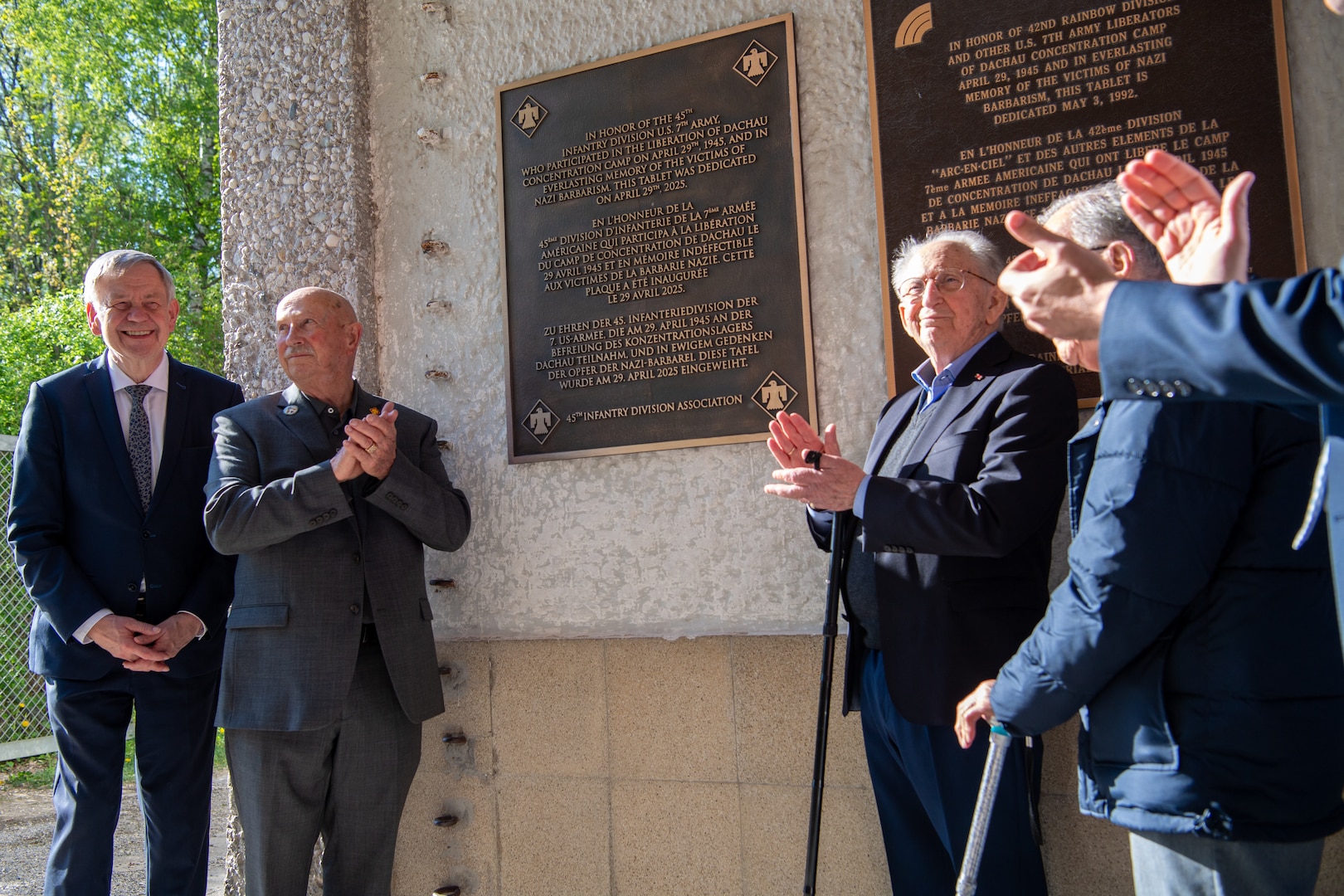 (second from left) Charles Giddons, a member of the 45th Infantry Division Association, joins a Holocaust survivor in unveiling a plaque at the Dachau Concentration Camp Memorial Site on April 29, 2025 honoring Soldiers of the 45th Infantry Division who participated in the liberation of the Dachau Concentration Camp on April 29, 1945. The plaque was unveiled by members of the Oklahoma National Guard, 45th Infantry Division Association, a Holocaust survivor and a member of the 20th Armored Division who assisted in the liberation, as well as members of the Bavarian Memorial Foundation, the Comité International de Dachau, on the 80th anniversary of the camp’s liberation. (Oklahoma National Guard Photo by Staff Sgt. Anthony Jones)