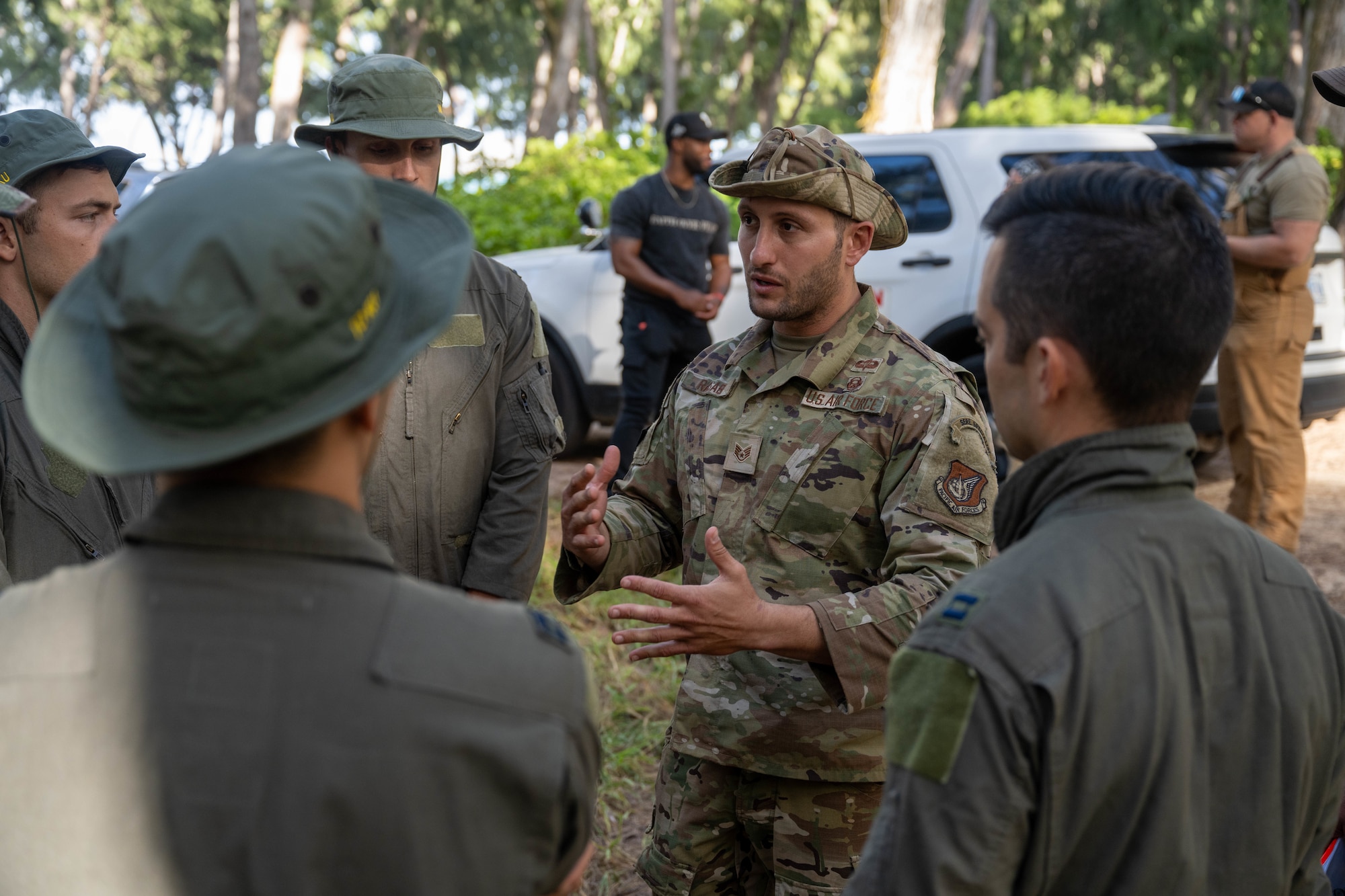 A U.S. Air Force Airmen talks to pilots prior to beginning a simulated hunt using military working dogs.
