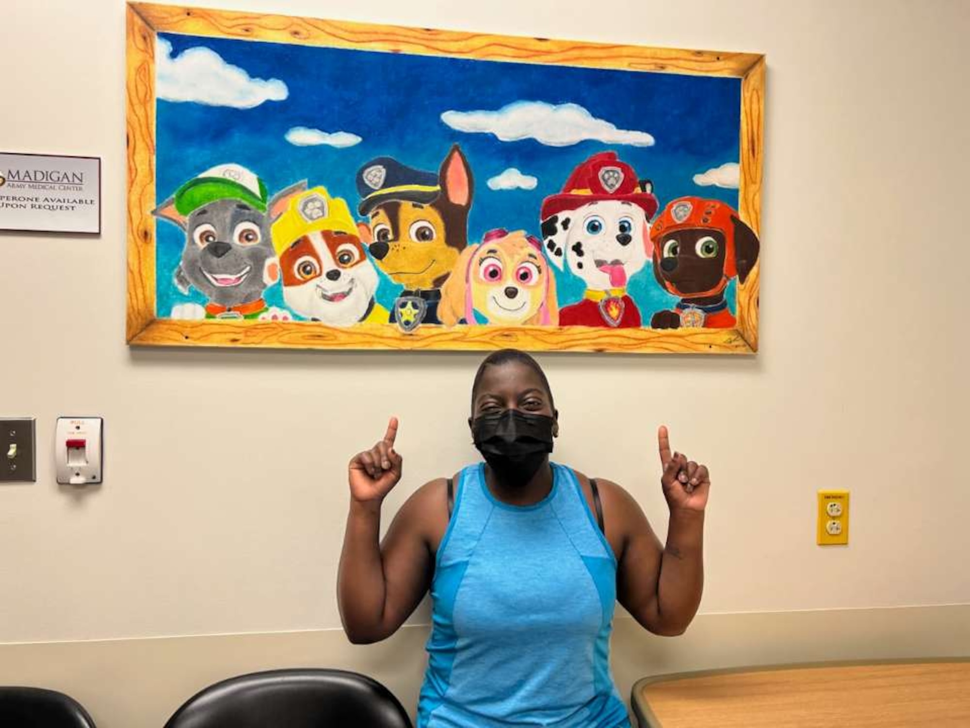 U.S. Air Force Staff Sgt. Briana Antoine-Bazan, 62d Aerial Port Squadron air terminal operations center information controller, stands in front of her art piece at Joint Base Lewis-McChord, Washington, Jan. 30, 2023.