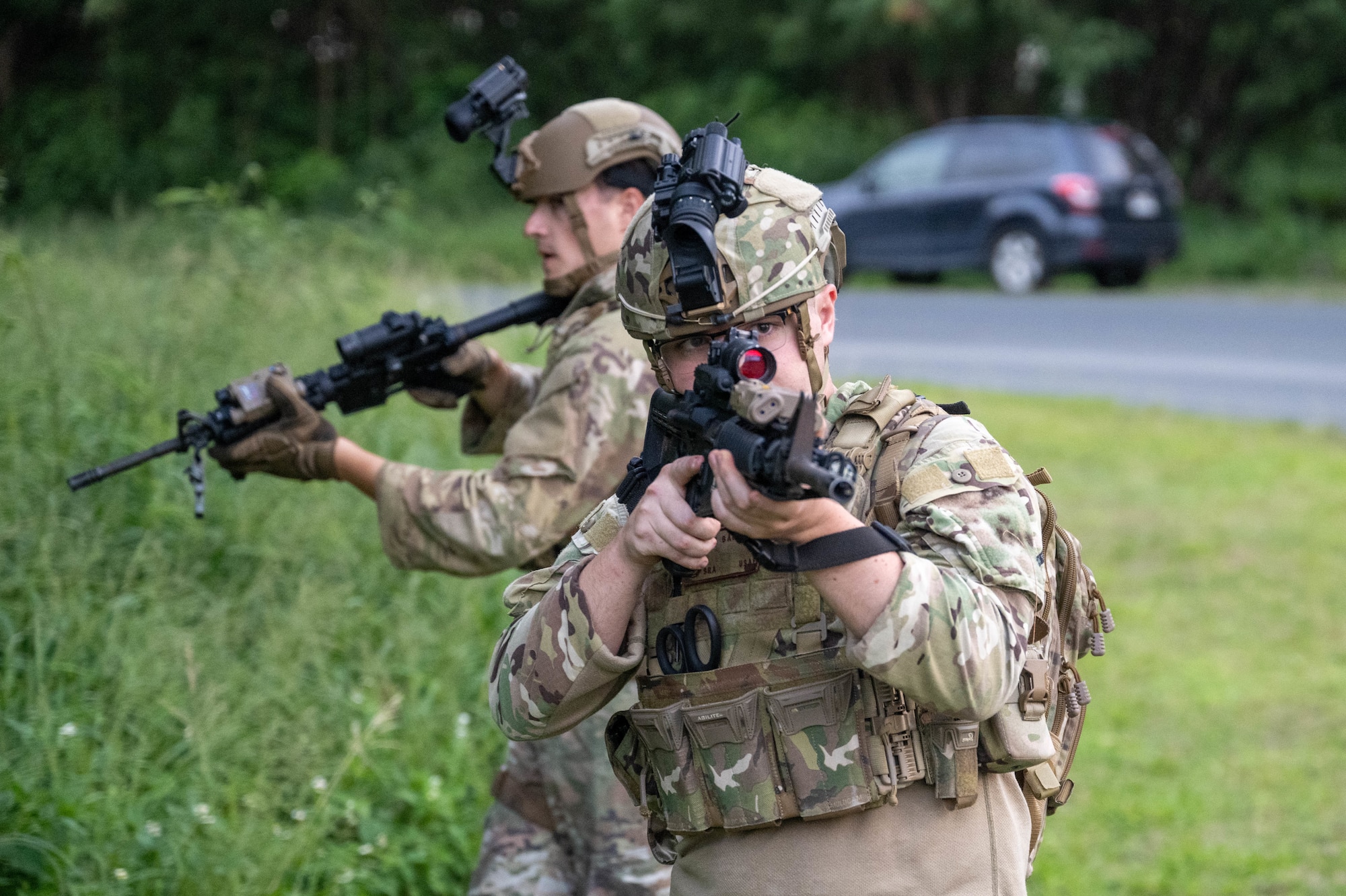 Two U.S. Air Force Security Forces defenders move in a patrol along a road.