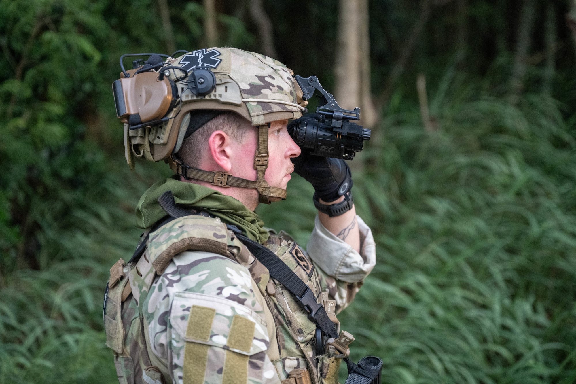 U.S. Air Force Airman calibrates his night vision lens in the woods near Bellows Air Force Station, Hawaii.