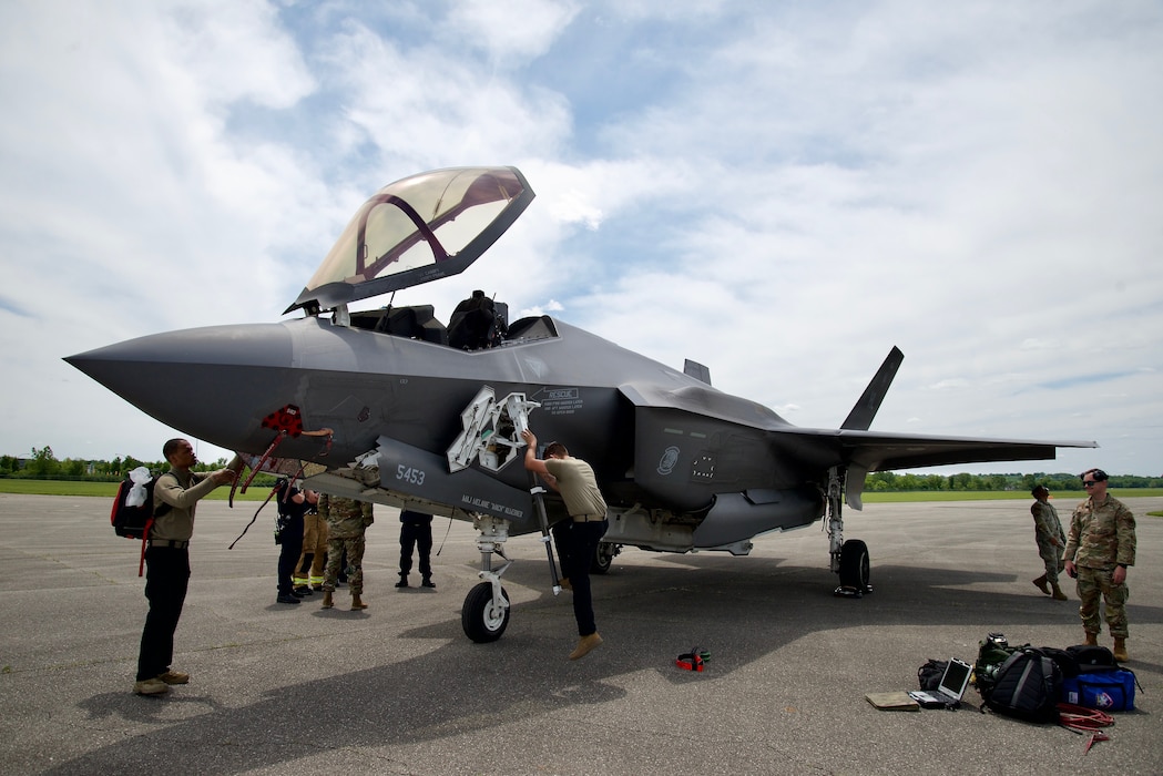Military members work on a military plane.
