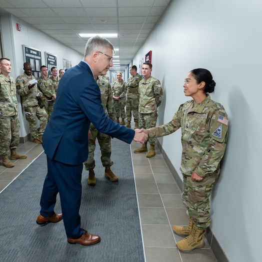  Secretary of the Air Force Troy Meink presents a challenge coin to U.S. Space Force Sgt. Catherine Bolanos of Space Delta 9 (Orbital Warfare) at Schriever Space Force Base, Colorado, May 28, 2025. Space Operations Command Guardians and Airmen demonstrated their combat readiness and warrior ethos, providing Meink with a deep dive into multiple critical mission areas, to include Space Domain Awareness; Electromagnetic Warfare; Missile Warning; Intelligence, Surveillance, Reconnaissance and Targeting; Orbital Warfare and Positioning, Navigation and Timing; as well as the critical mission support provided by the U.S. Air Force.  (U.S. Space Force photo by Dave Grim)