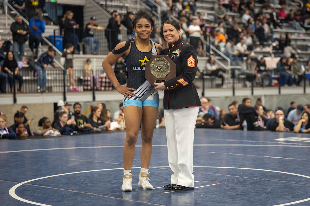 U.S. Marine Corps Gunnery Sgt. Courtney White, communication strategy and operations chief with 12th Marine Corps District, Marine Corps Recruiting Command, presents an award to a national champion during the 2025 U.S. Marine Corps Women's National Championships in Spokane, Washington, April 6, 2025. The Marine Corps is proud to partner with USA Wrestling and hopes to strengthen relationships with the American people and showcase the Marine Corps’ purpose, values, and service opportunities. White is a native of Chula Vista, California. (U.S. Marine Corps photo by Sgt. Hunter Wagner)